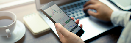 Hand Holding Smartphone with Stock Graph